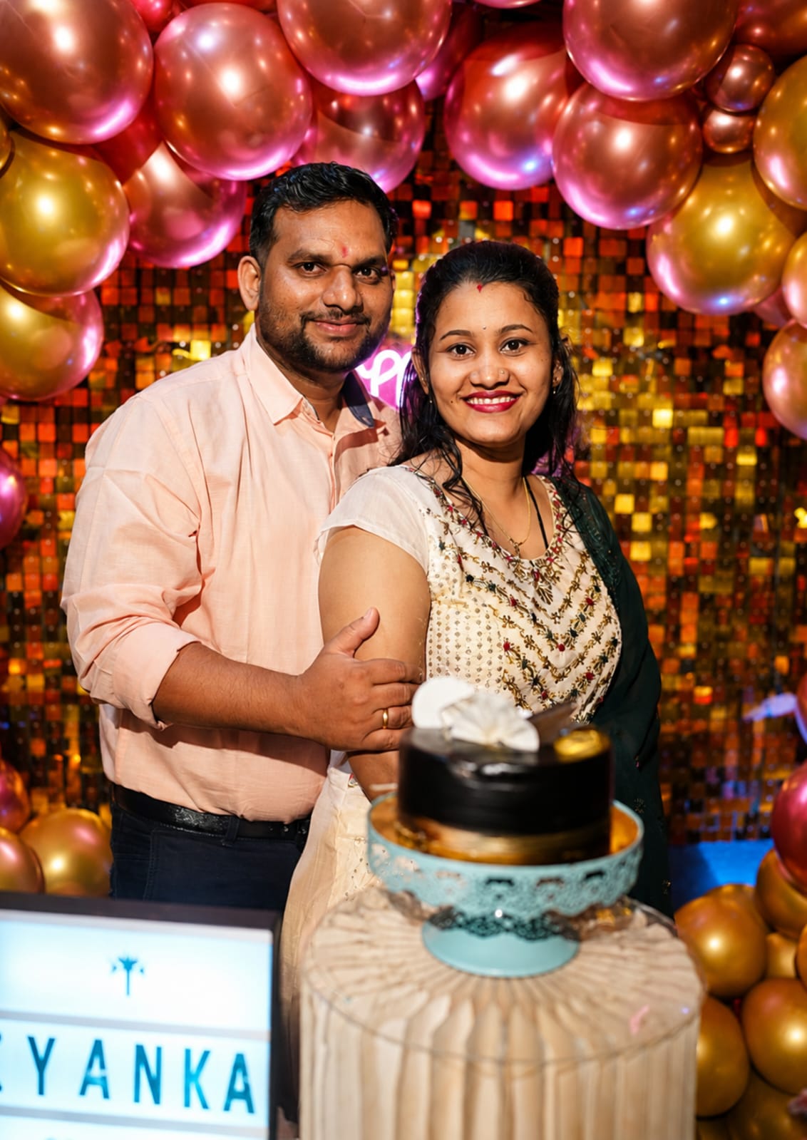 Couple celebrating in a balloon-filled Surprise Town setup