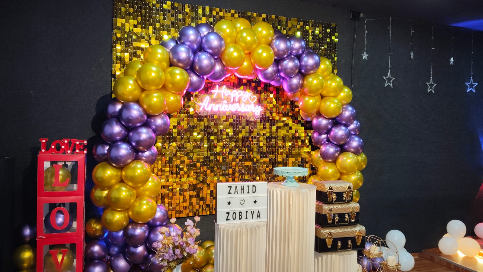Gold and purple anniversary balloon arch